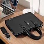A luxurious black leather briefcase with silver accents, placed on a wooden chair, showcasing its sleek design and premium quality.