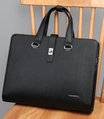 A luxurious black leather briefcase with silver accents, placed on a wooden chair, showcasing its sleek design and premium quality.