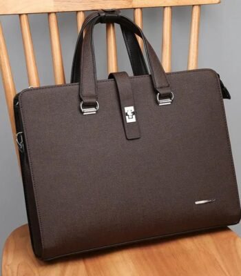 A brown leather laptop briefcase sitting on a wooden chair, showcasing its sleek design and silver accents.