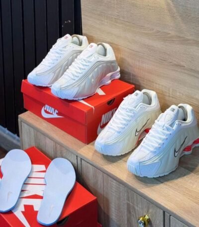 A pair of white Nike Air Max 270 React sneakers with red accents, showcasing Modern Luxury and Urban Edge style.