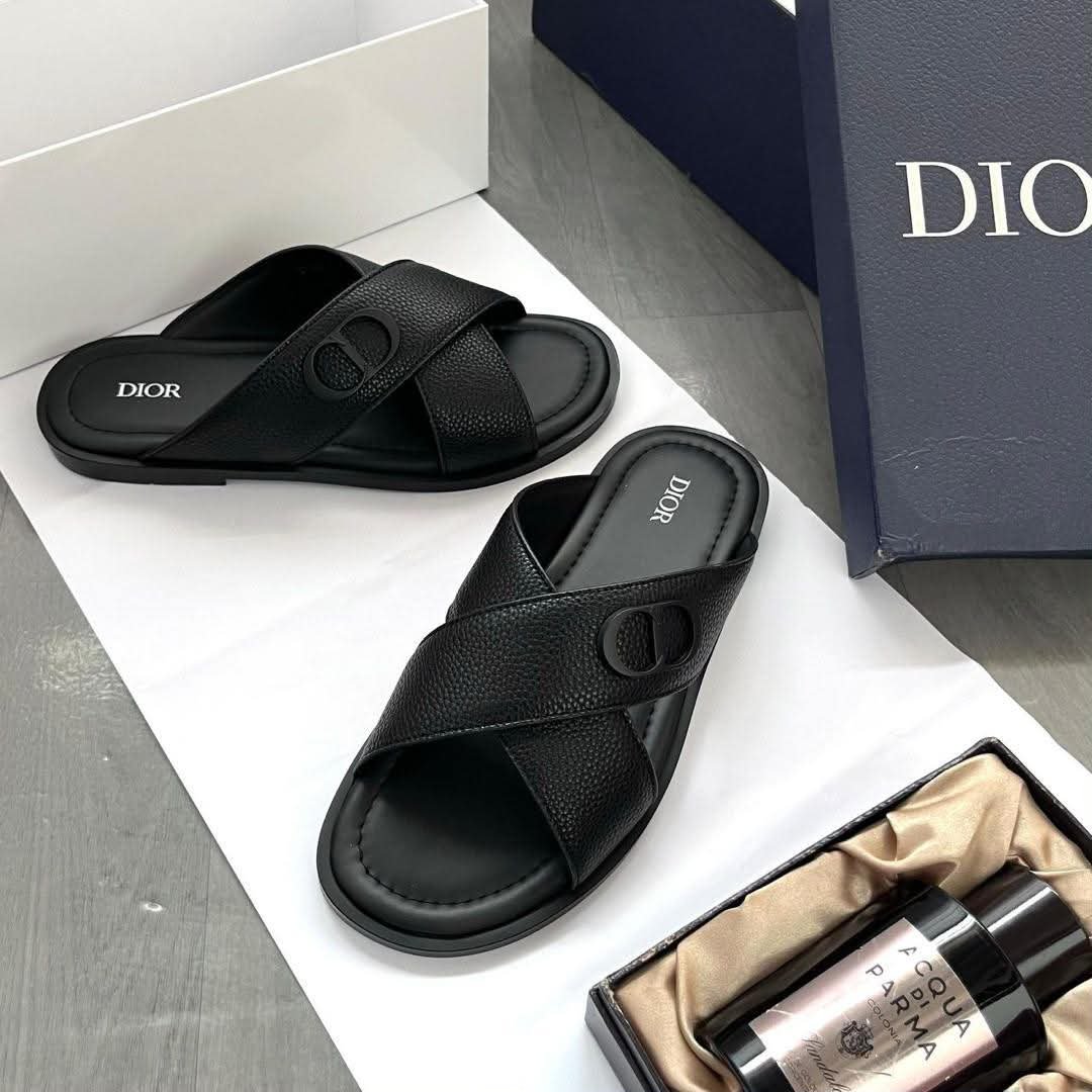 root A pair of black leather Dior slides with white logo on a white background, showcasing Modern Luxury and Urban Edge style.