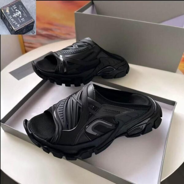 A pair of black Balenciaga rubber mules in a shoe box, showcasing the modern design and luxury quality of the shoes.