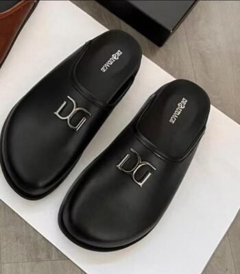 A pair of black leather slides with a silver Dolce & Gabbana logo, exuding luxury and sophistication.