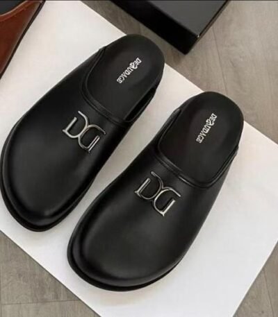 A pair of black leather slides with a silver Dolce & Gabbana logo, exuding luxury and sophistication.