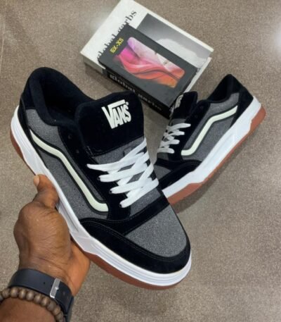 A pair of black and grey Vans skateboarding shoes with white laces and brown soles, showcasing Modern Luxury and Urban Edge.