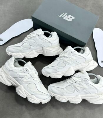 A stunning visual showcasing the New Balance 574S Triple White Sneakers, elegantly arranged with their box and insoles, highlighting the exceptional craftsmanship and attention to detail.