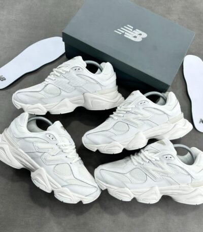A stunning visual showcasing the New Balance 574S Triple White Sneakers, elegantly arranged with their box and insoles, highlighting the exceptional craftsmanship and attention to detail.