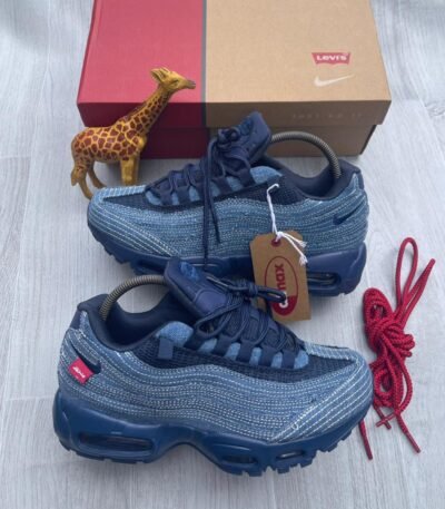 A pair of denim blue Nike Air Max sneakers with red accents, showcasing Modern Luxury and Urban Edge style, perfect for making a statement in Nigeria.