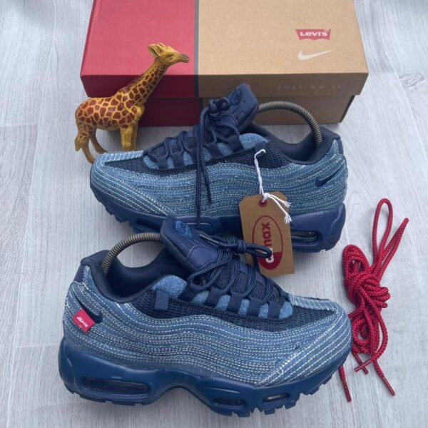 A pair of denim blue Nike Air Max sneakers with red accents, showcasing Modern Luxury and Urban Edge style, perfect for making a statement in Nigeria.