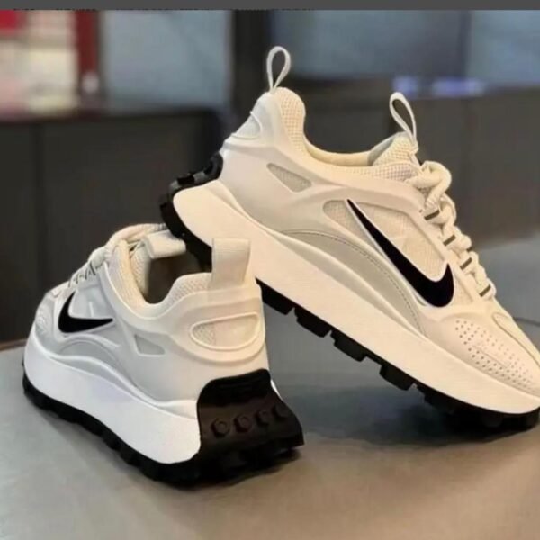 A pair of white Nike running shoes with black accents, showcasing sleek design and superior comfort for the urban man in Nigeria.
