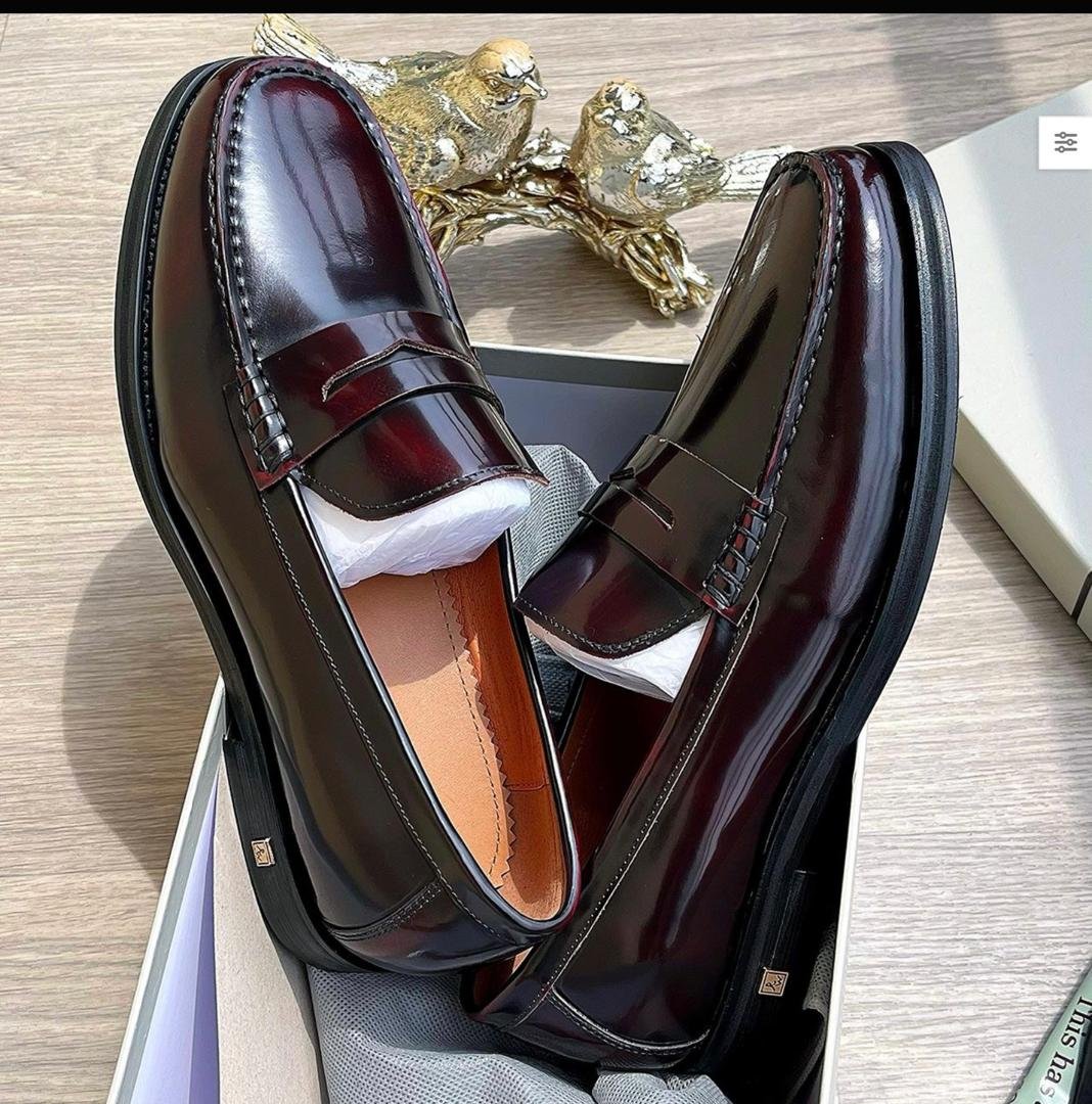 IMG-20260610-WA0020 A pair of luxurious burgundy leather loafers in a shoe box, showcasing modern luxury and urban edge with impeccable craftsmanship.