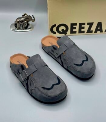 A pair of gray suede double-buckle mule shoes for men, showcasing Modern Luxury and Urban Edge style, perfect for adding a touch of sophistication to any outfit in Nigeria.