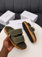 Modern luxury grey and orange sandals with white shoe boxes on a table, embodying urban edge and timeless quality.