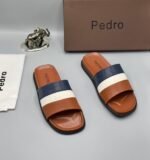 A pair of stylish brown slides with navy blue and white stripes, presented with a brown box and accessories.