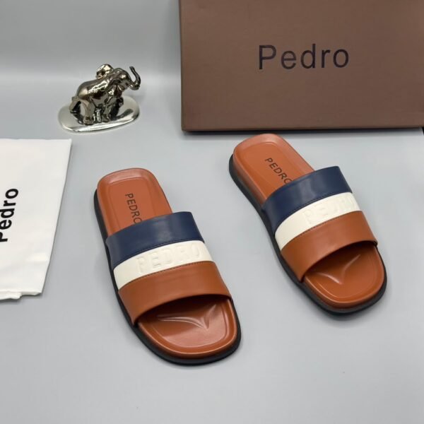 A pair of stylish brown slides with navy blue and white stripes, presented with a brown box and accessories.