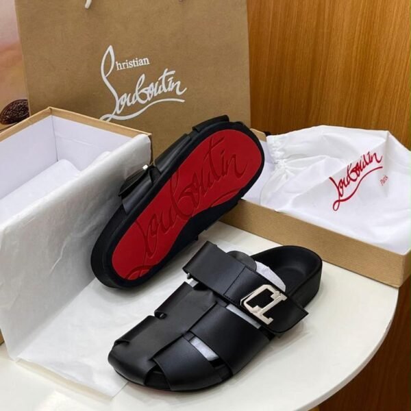Christian Louboutin black leather sandal with red sole, presented in a luxury setting with box and bag.