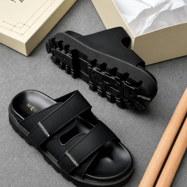 A pair of black leather sandals with a rugged sole and double strap design, presented with a shoe box and tissue paper, exuding Modern Luxury and Urban Edge.
