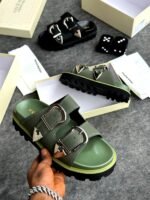 A pair of black sandals with silver buckles, showcased in a luxurious setting with Alexander McQueen branding, exuding Modern Luxury and Urban Edge.