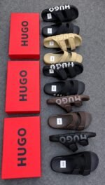 A pair of black and brown HUGO slides on red shoe boxes, showcasing Modern Luxury, Urban Edge, and Timeless Quality.