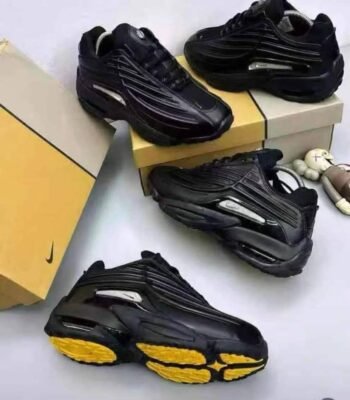 A stylish pair of black sneakers with yellow soles, embodying Modern Luxury and Urban Edge, displayed on a pristine white background.