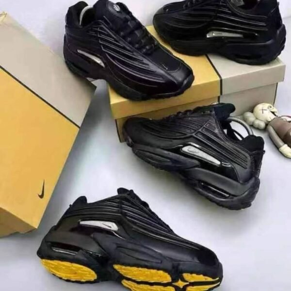 A stylish pair of black sneakers with yellow soles, embodying Modern Luxury and Urban Edge, displayed on a pristine white background.