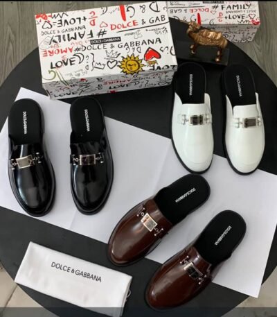 A stylish display of Dolce & Gabbana half shoes in black, brown, and white, accompanied by the brand's signature box and cloth bag.