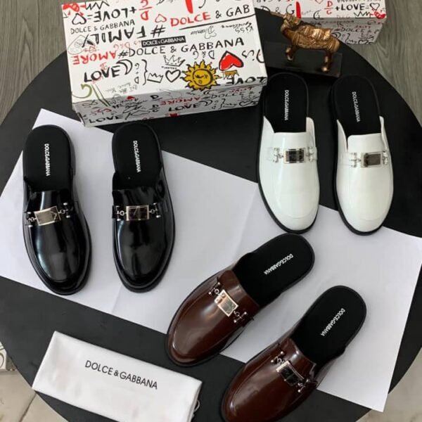 A stylish display of Dolce & Gabbana half shoes in black, brown, and white, accompanied by the brand's signature box and cloth bag.