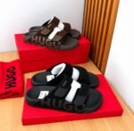 A pair of black and brown HUGO slides on red shoe boxes, showcasing Modern Luxury, Urban Edge, and Timeless Quality.