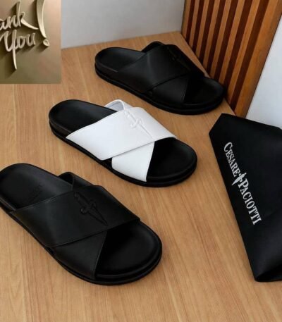 A stylish display of luxurious slides in black and white, accompanied by a branded dust bag, showcasing modern design and timeless quality.