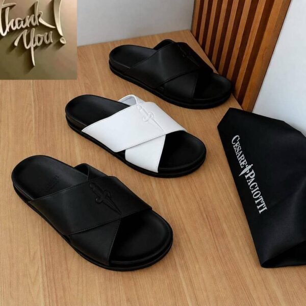 A stylish display of luxurious slides in black and white, accompanied by a branded dust bag, showcasing modern design and timeless quality.