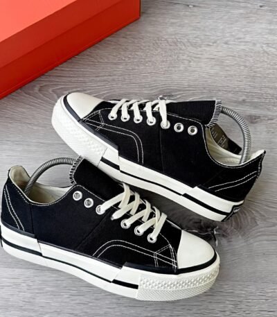 A pair of black sneakers with white laces and soles, showcasing a sleek and modern design.