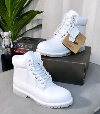 A pair of pristine white boots with silver laces and a chunky sole, exuding Modern Luxury and Urban Edge on a stylish background.