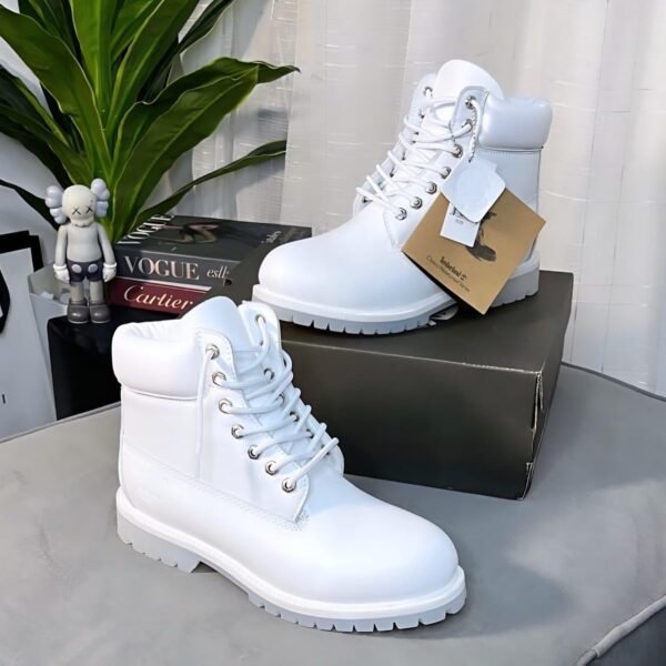 A pair of pristine white boots with silver laces and a chunky sole, exuding Modern Luxury and Urban Edge on a stylish background.
