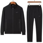 A stylish grey tracksuit consisting of a zip-up jacket and matching joggers, both featuring the Nike logo, displayed on hangers against a white background.